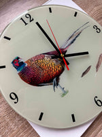 close up detail of a pheasant wall clock on a green background