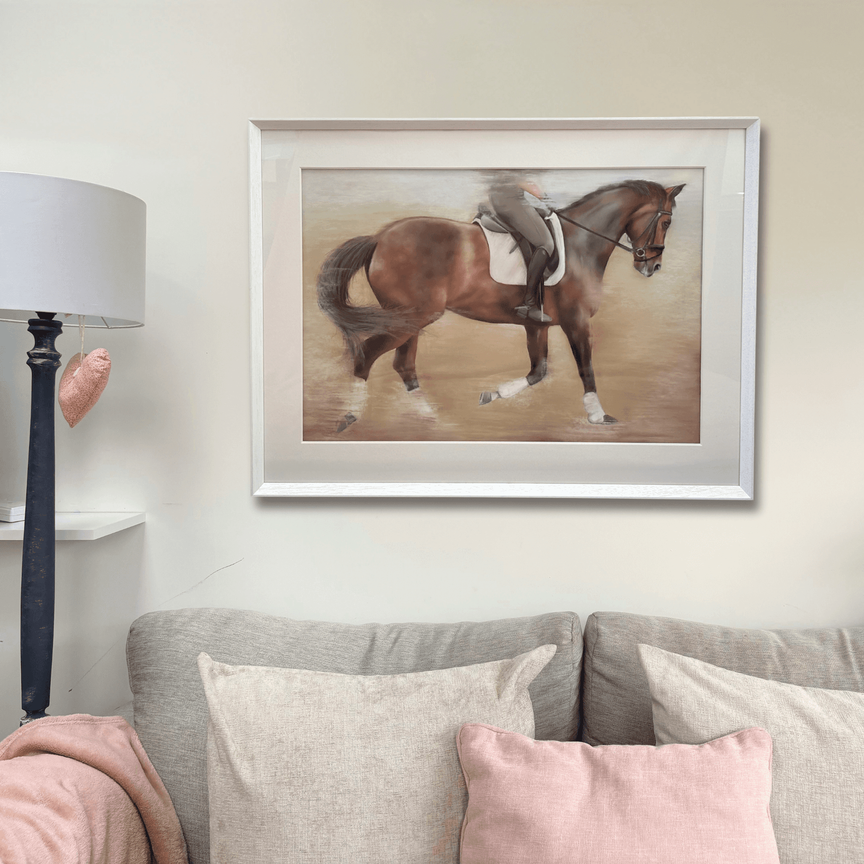 Framed dressage horse original artwork displayed above a sofa in a cozy country-style living room. Ideal large wall art for equestrian home decor.