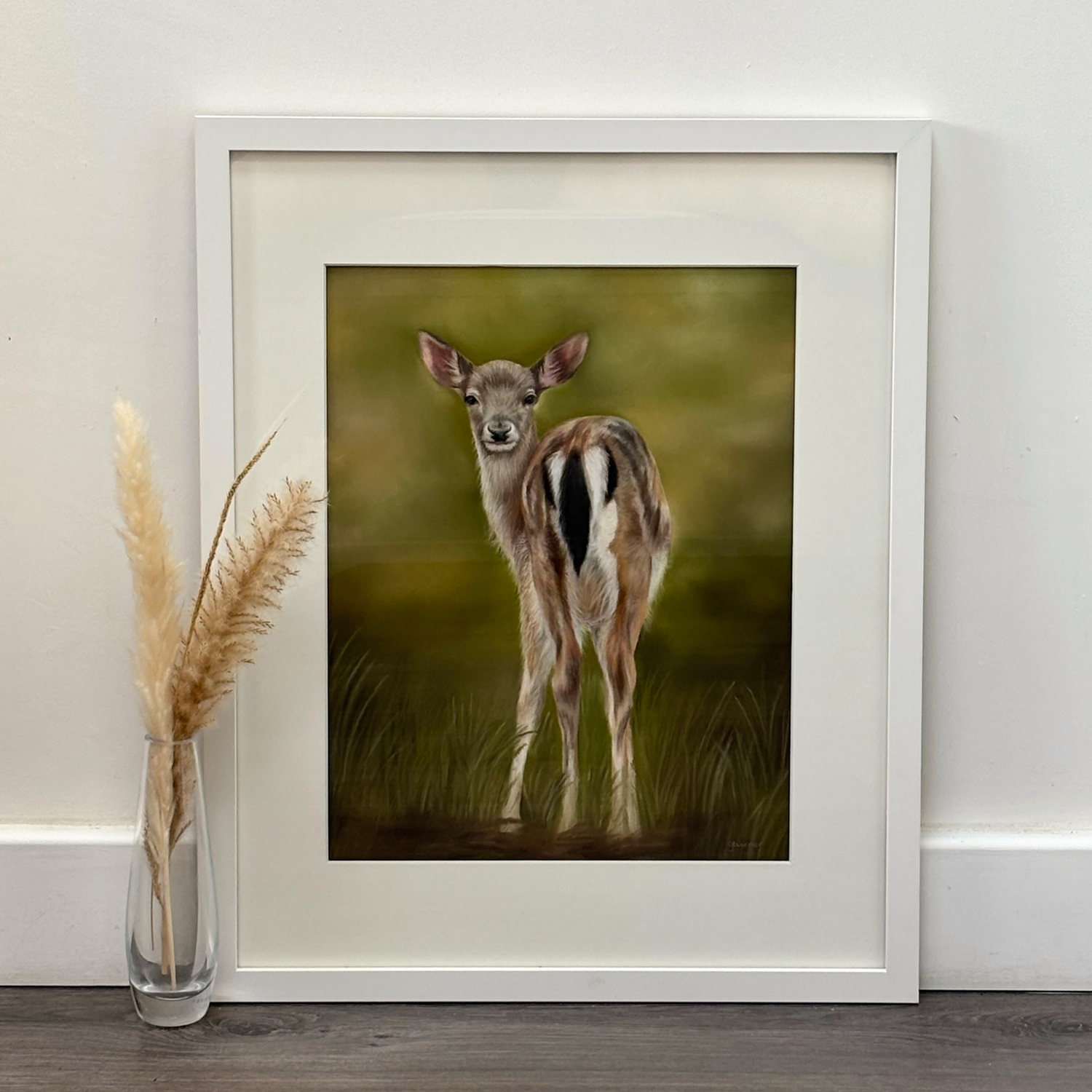 Framed fawn original artwork titled 'Fallow Fawn' displayed on floor with pampas grass, ideal for country home decor and wildlife-themed wall art.