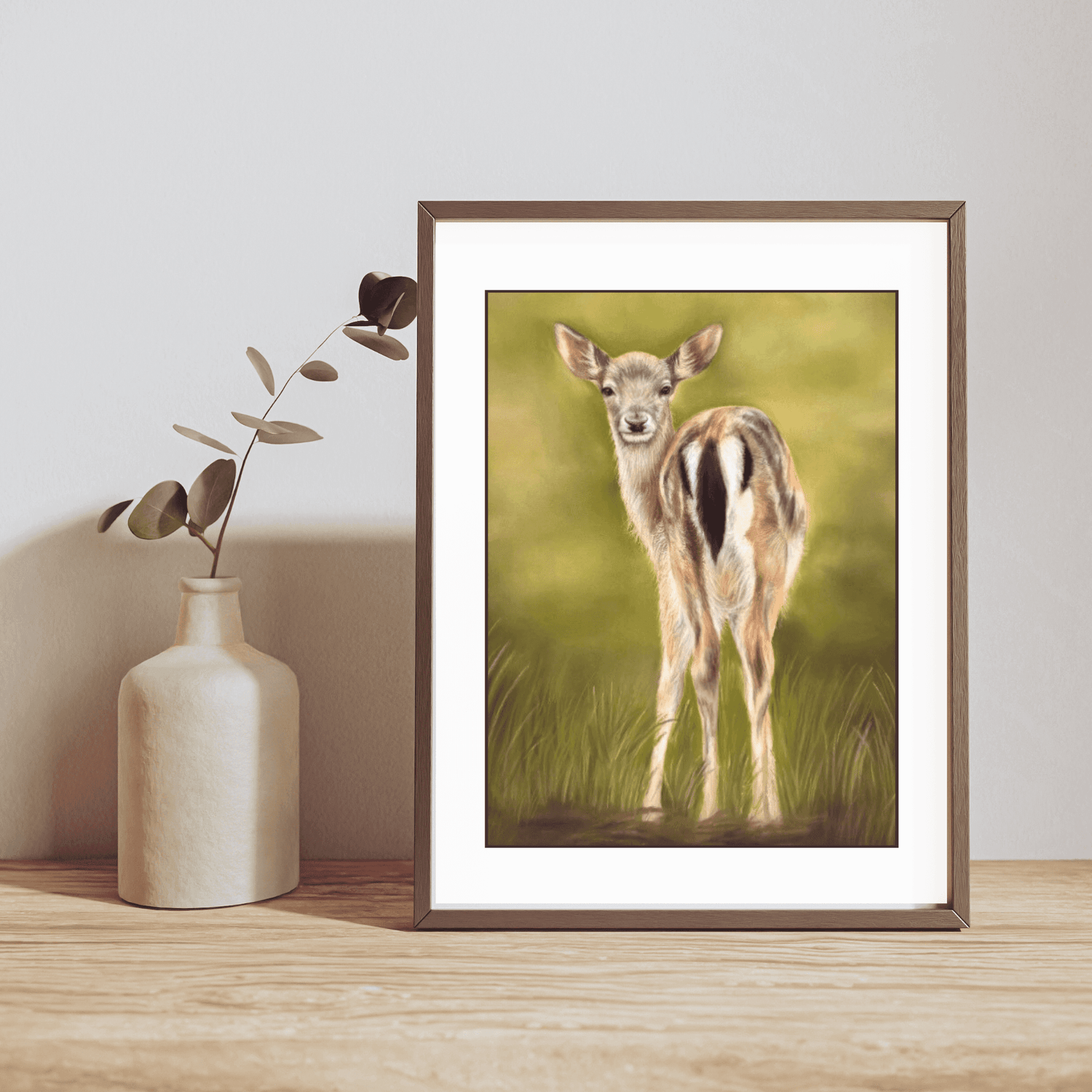 Fallow Fawn Fine Art Print On Paper in a dark wooden frame, styled on a wooden shelf with a ceramic vase, ideal for British countryside decor.