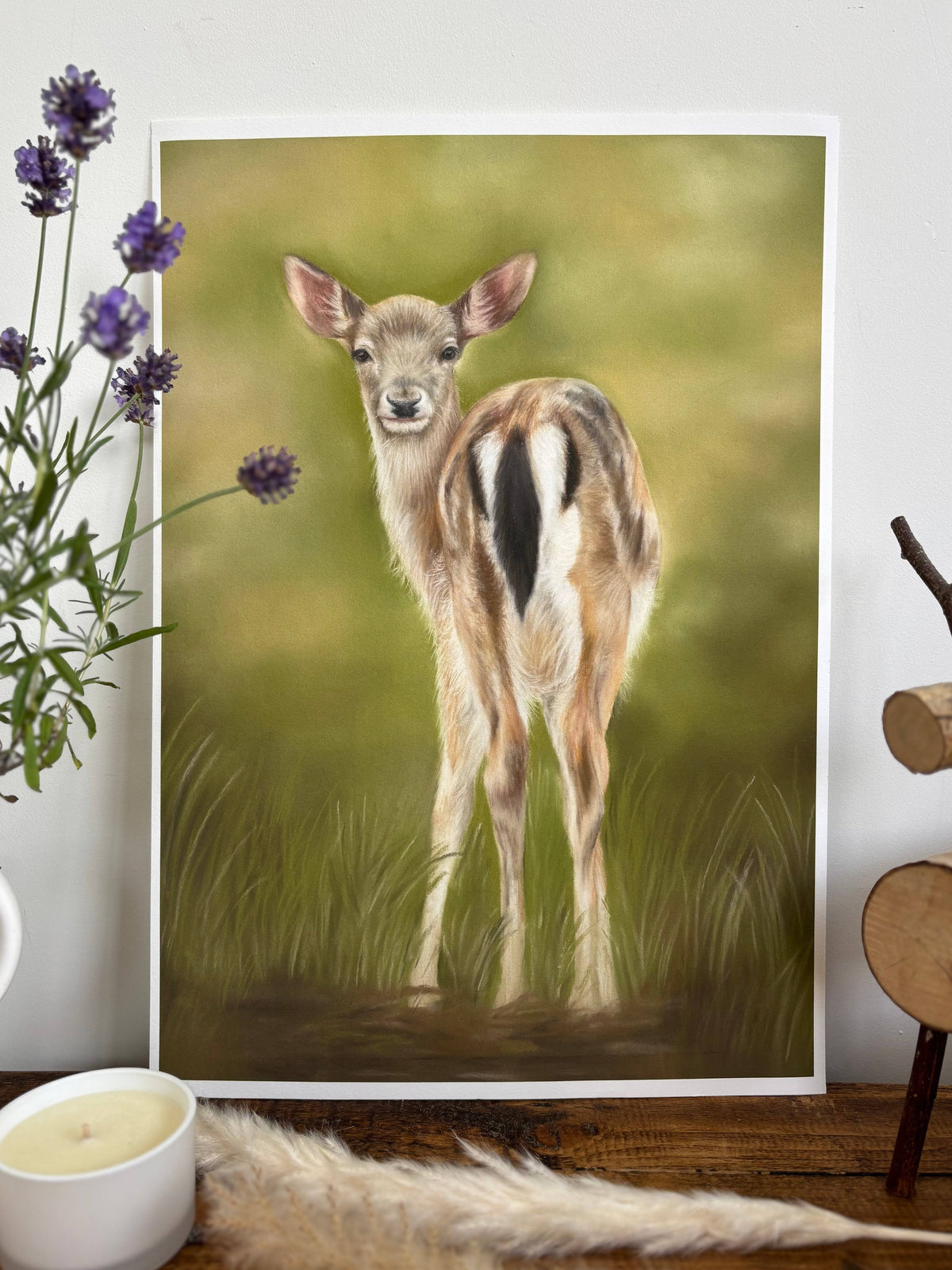 Fallow Fawn Fine Art Print On Paper leaning against a wall with natural decor elements, showcasing woodland charm for home and garden spaces.