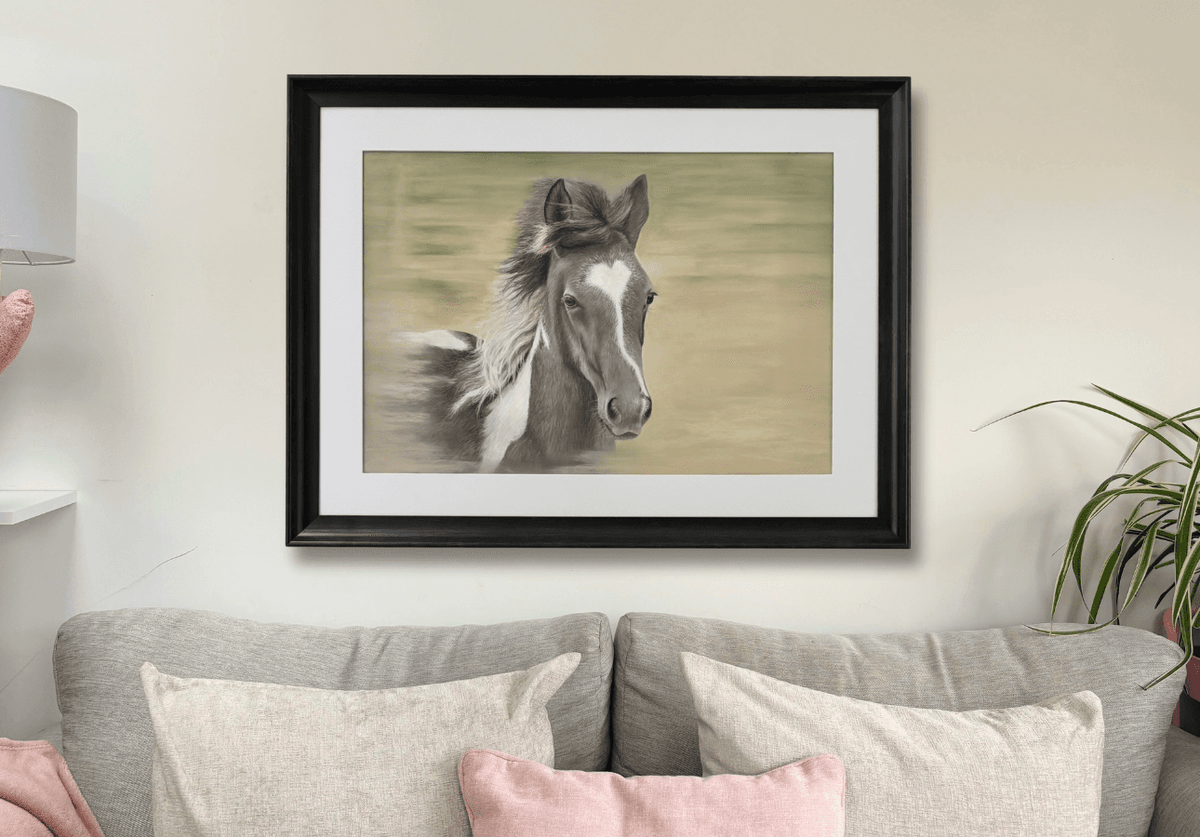 Large wall art of a foal titled 'Flying Free' in a black frame, styled in a cozy living room for country home decor inspiration.