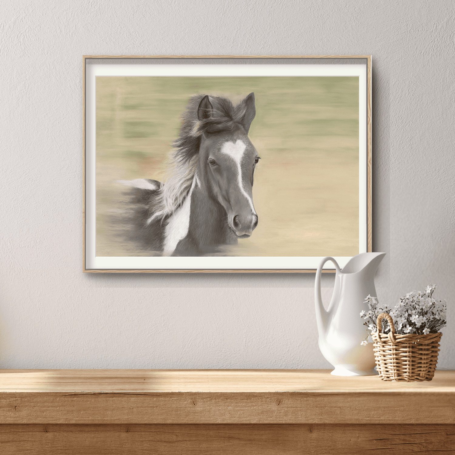 Framed Galloping Foal Fine Art Print by Georgie Turner on a rustic console table, perfect for adding equestrian charm to home interiors.