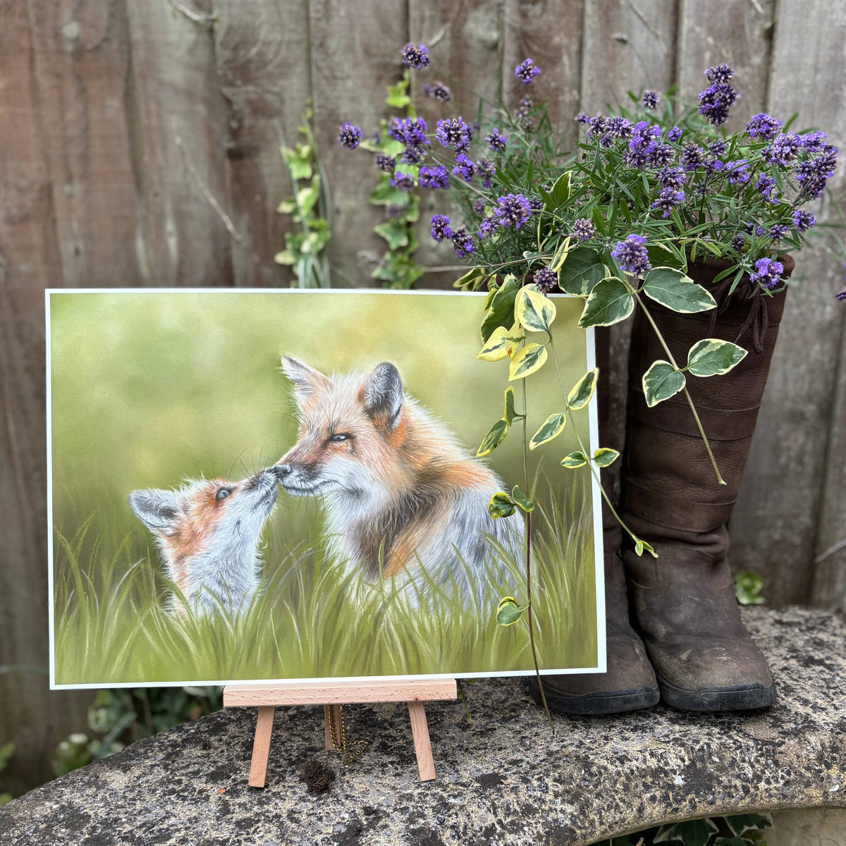 Fox & Cub Fine Art Print On Paper displayed outdoors with flowers and boots, reflecting rustic British countryside interior style.