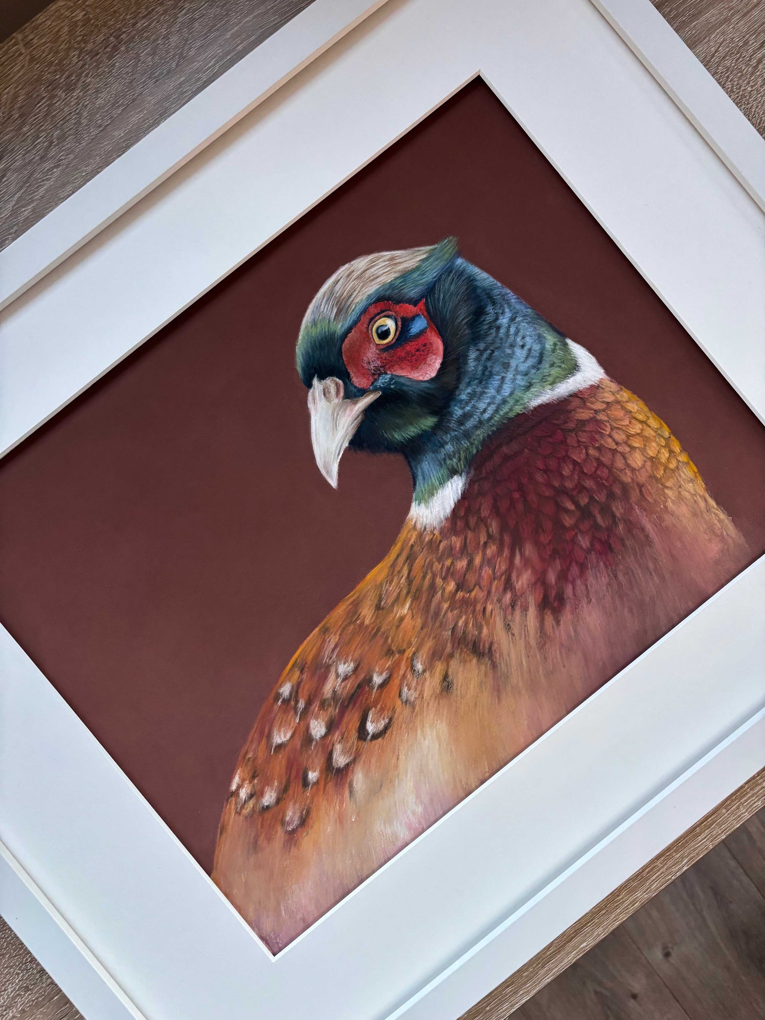 Close-up of framed pheasant painting 'Gerald' by Georgie Turner, showcasing detailed feathers and vibrant colors for country-themed interiors.