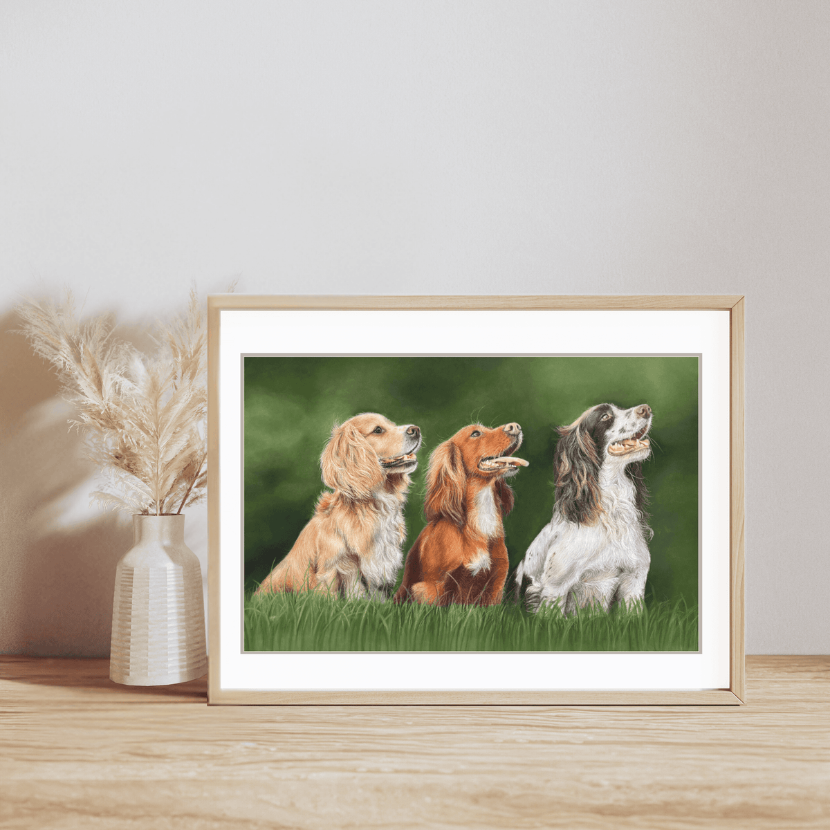 Country wall art print of three gun dogs in a grassy field, framed for display. A fine art print for field sport and spaniel enthusiasts.