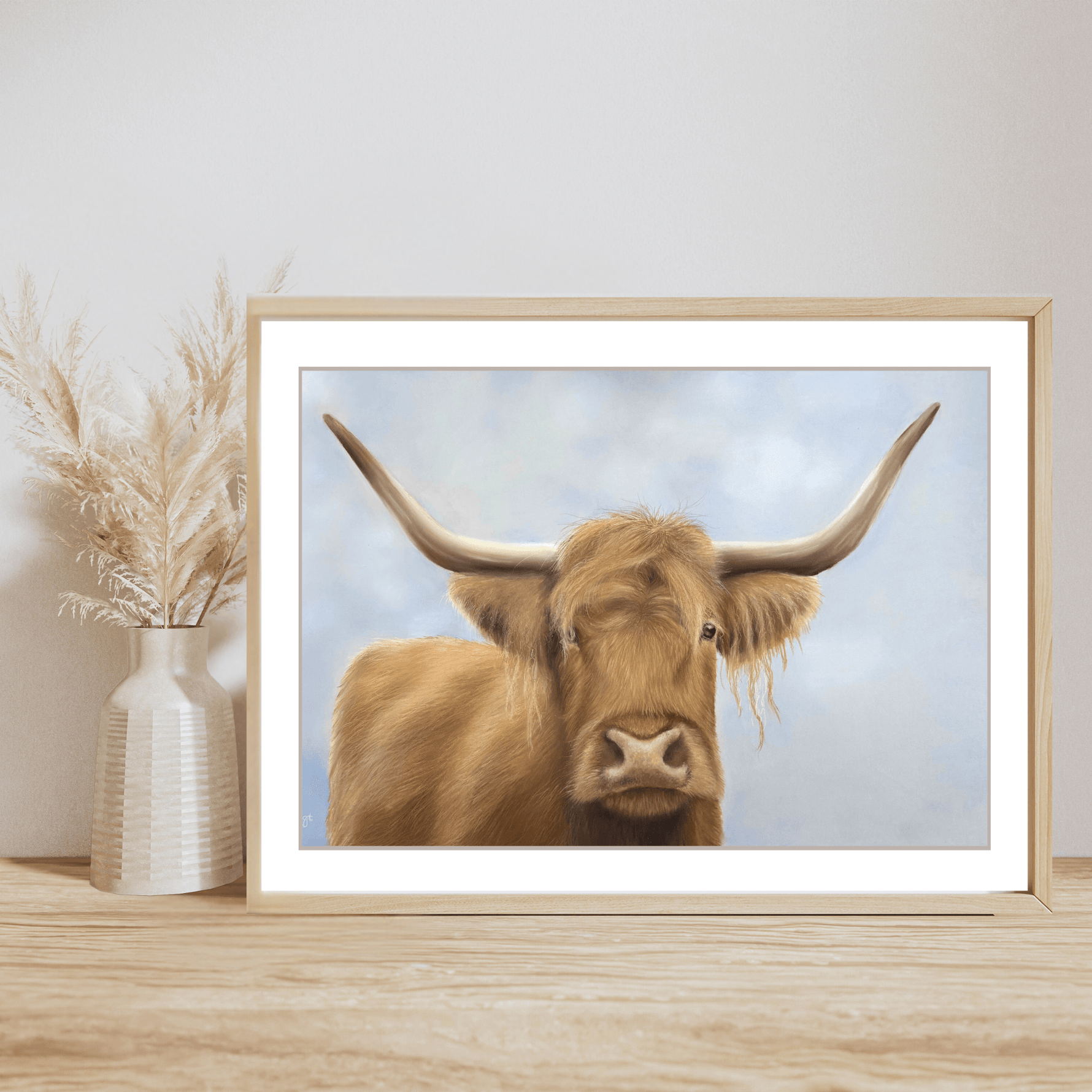 Scottish Highland Cow Print fine art giclee in wooden frame on wooden shelf with pampas grass vase. Ideal farming wall print for rustic home decor.