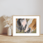 Horse Muzzle Fine Art Print displayed in a light wood frame on a wooden surface, featuring a close-up of two horse muzzles touching gently.