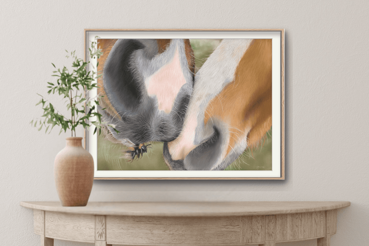 Horse Muzzle Fine Art Print in a minimalist frame above a wooden table, capturing a tender interaction between two horses' noses in fine detail.