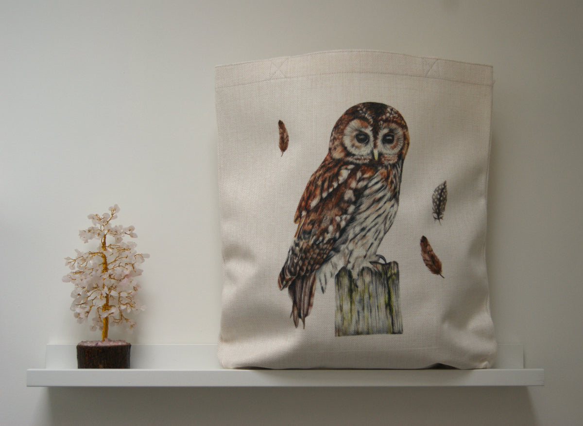 Tawny owl tote bag with realistic owl artwork and feathers, displayed on a shelf, ideal for eco-conscious shoppers and owl enthusiasts.
