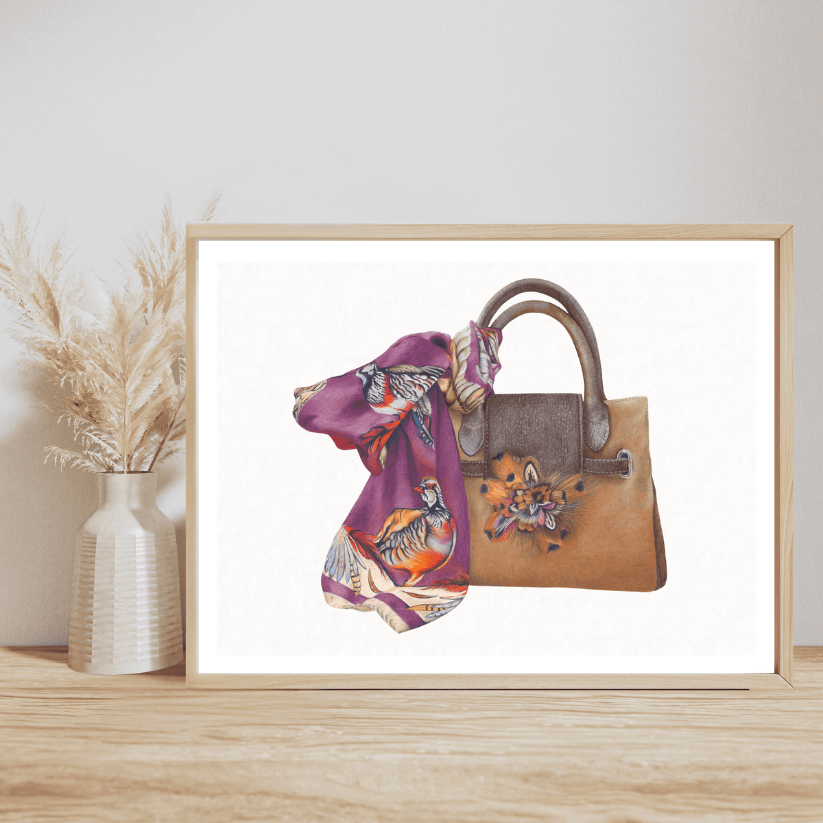 Bag & Scarf Fine Art Print on Paper featuring a tan handbag with floral detail and a vibrant purple scarf, styled on a wooden shelf with pampas grass decor.