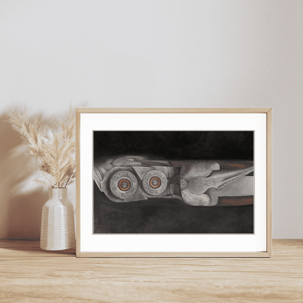 Shooting Fine Art Print featuring a close-up of a double-barrel shotgun with cartridges, framed and displayed on a wooden shelf with pampas grass decor.