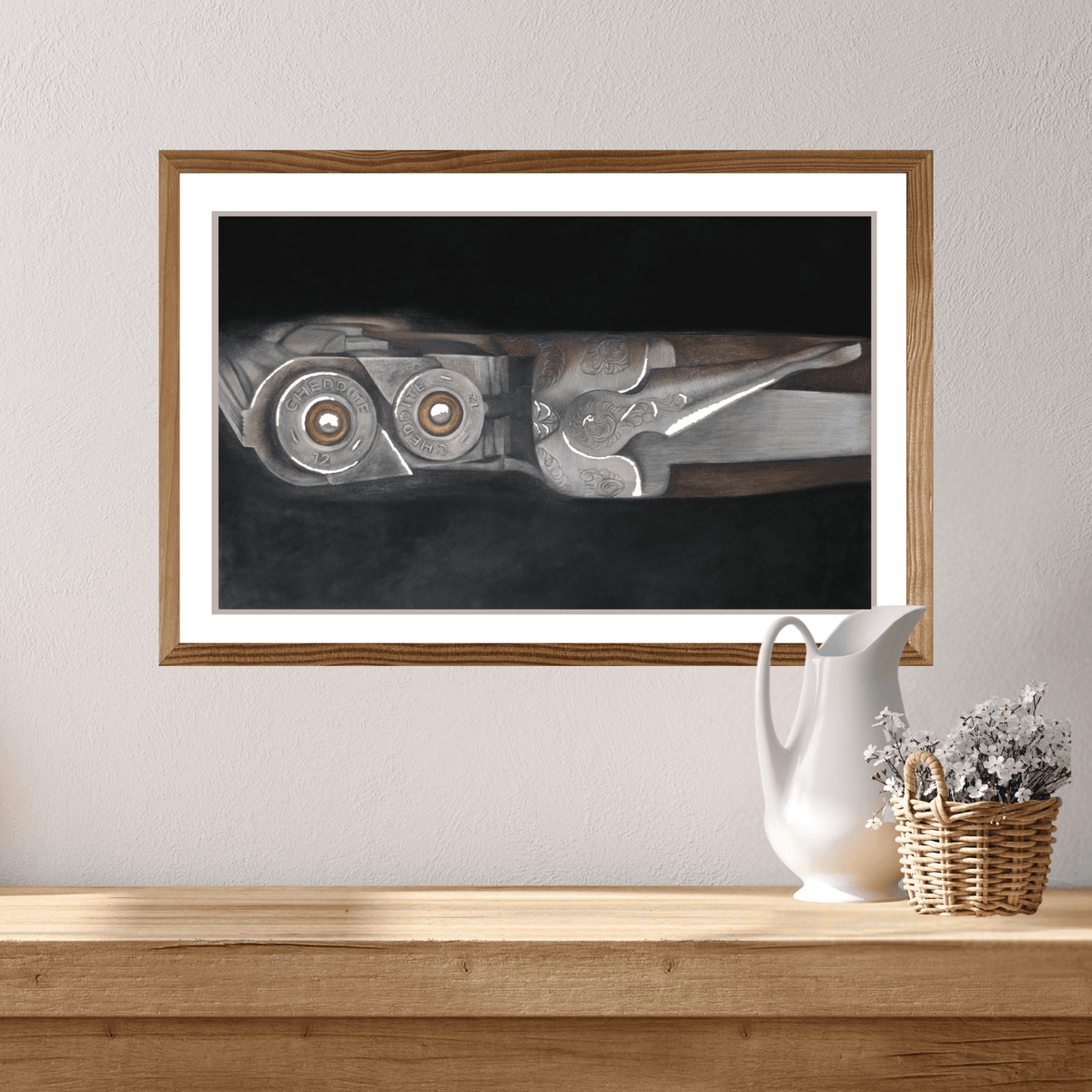 Shooting Fine Art Print of a shotgun and cartridges in a wood and metal finish, framed and mounted above a rustic console with a wicker basket and flowers.