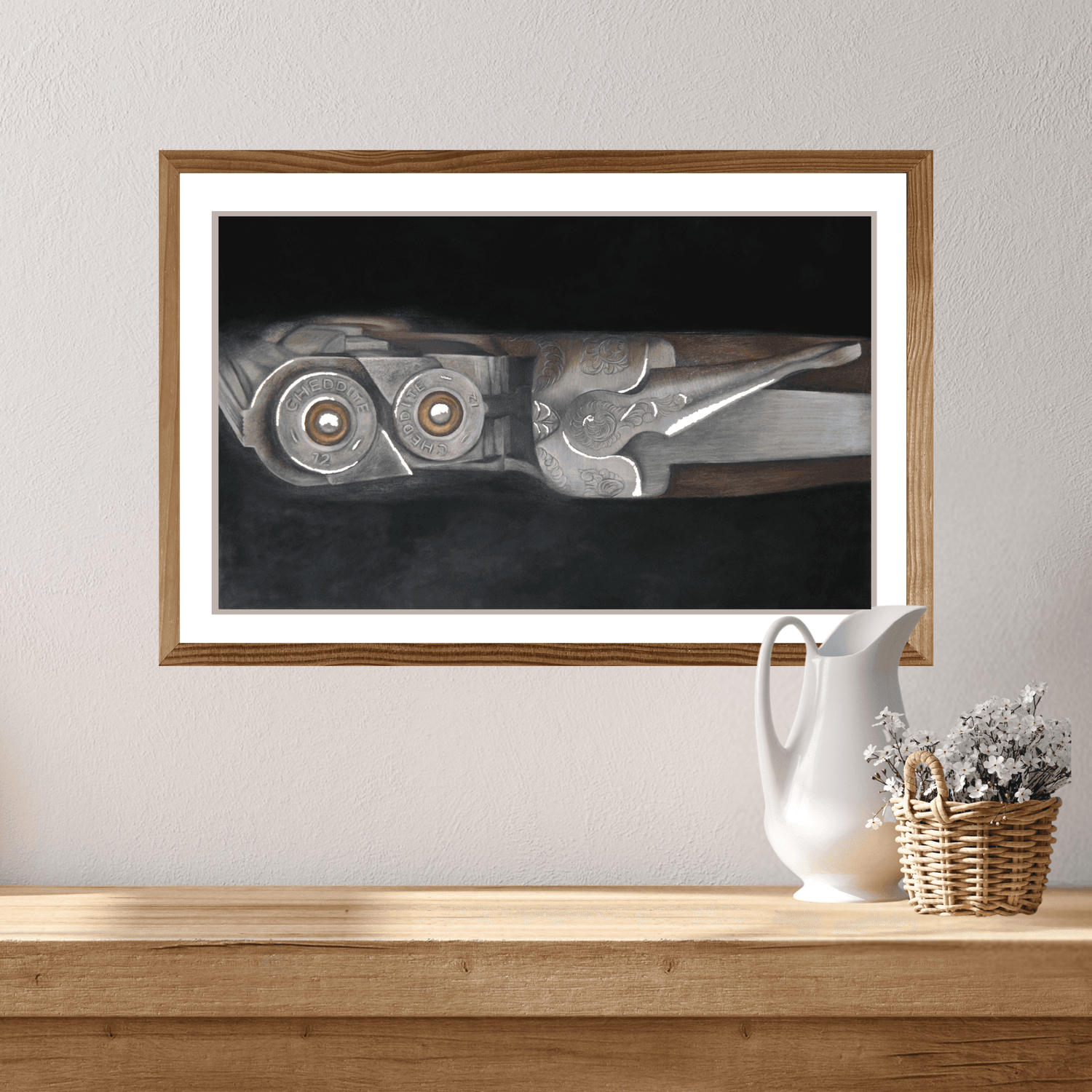 Shooting Fine Art Print of a shotgun and cartridges in a wood and metal finish, framed and mounted above a rustic console with a wicker basket and flowers.