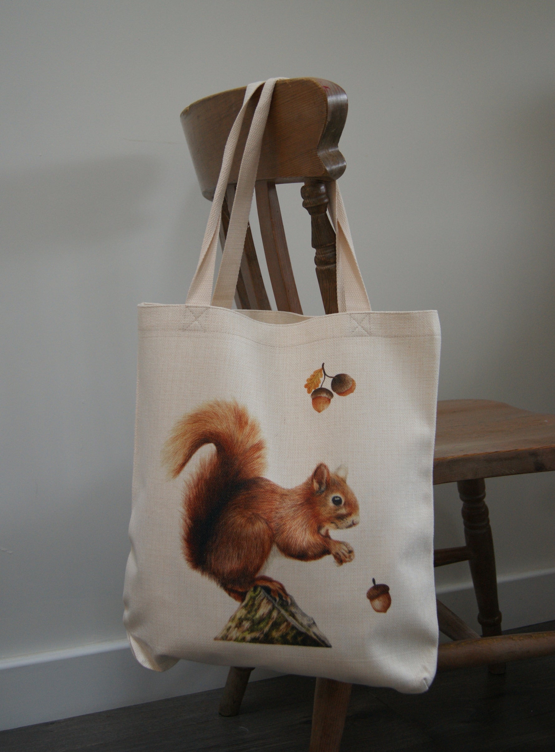 Squirrel tote bag with eco-friendly linen fabric featuring a red squirrel and acorns artwork. Ideal reusable shopping bag for women and nature lovers.