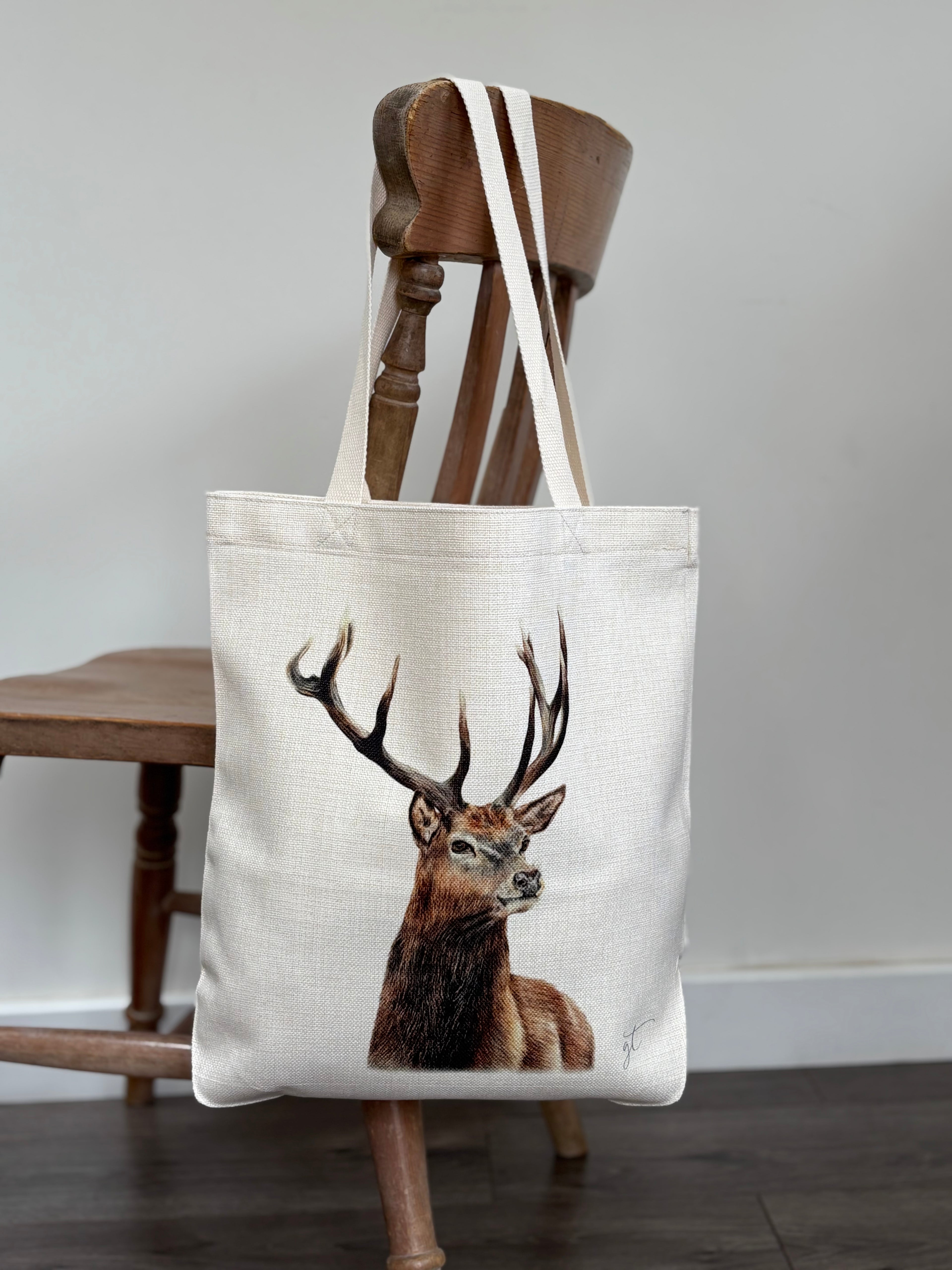 Stag tote bag with realistic stag artwork, eco-friendly linen shopping bag hanging on a wooden chair. Ideal tote bag for women and nature lovers.