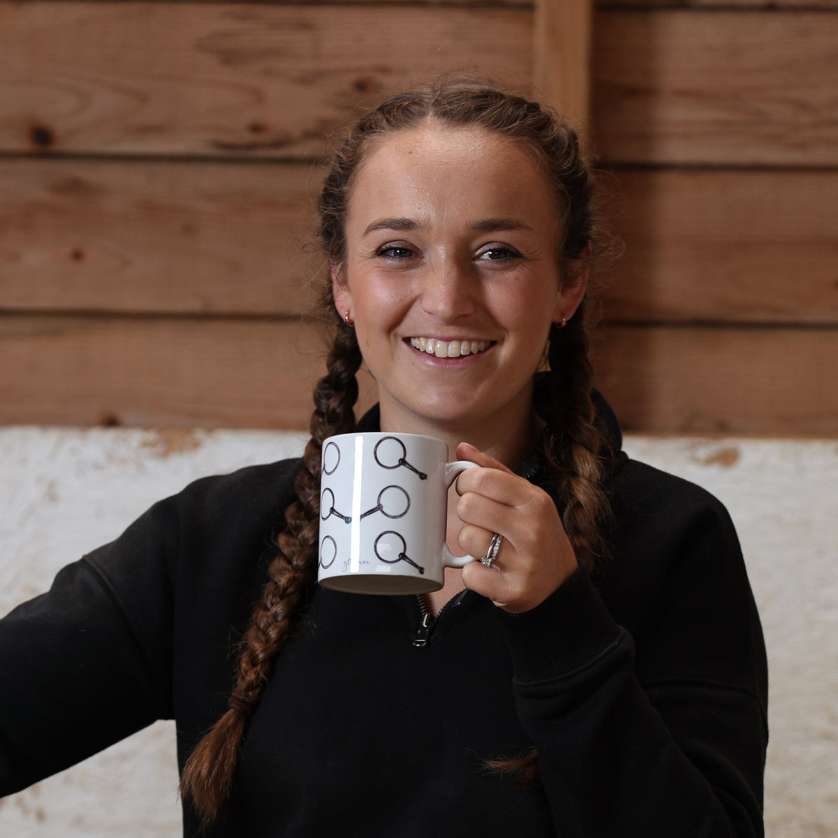 Georgie Turner holding an equestrian mug in the stable
