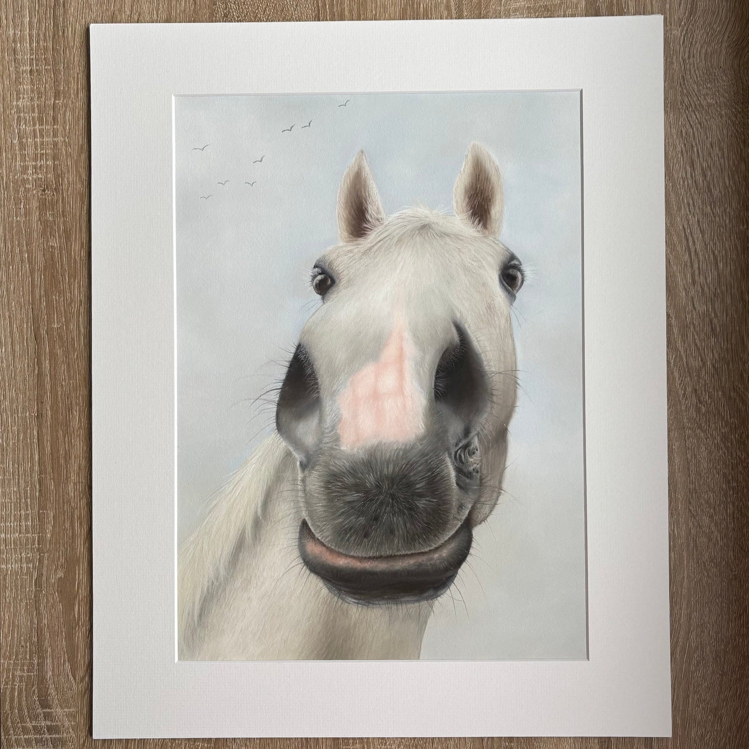 Framed print of a horse's face on a wooden surface