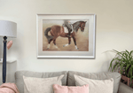 Equestrian-themed original artwork of a dressage horse framed and mounted above a neutral-toned sofa. Perfect for rustic or country home interiors.
