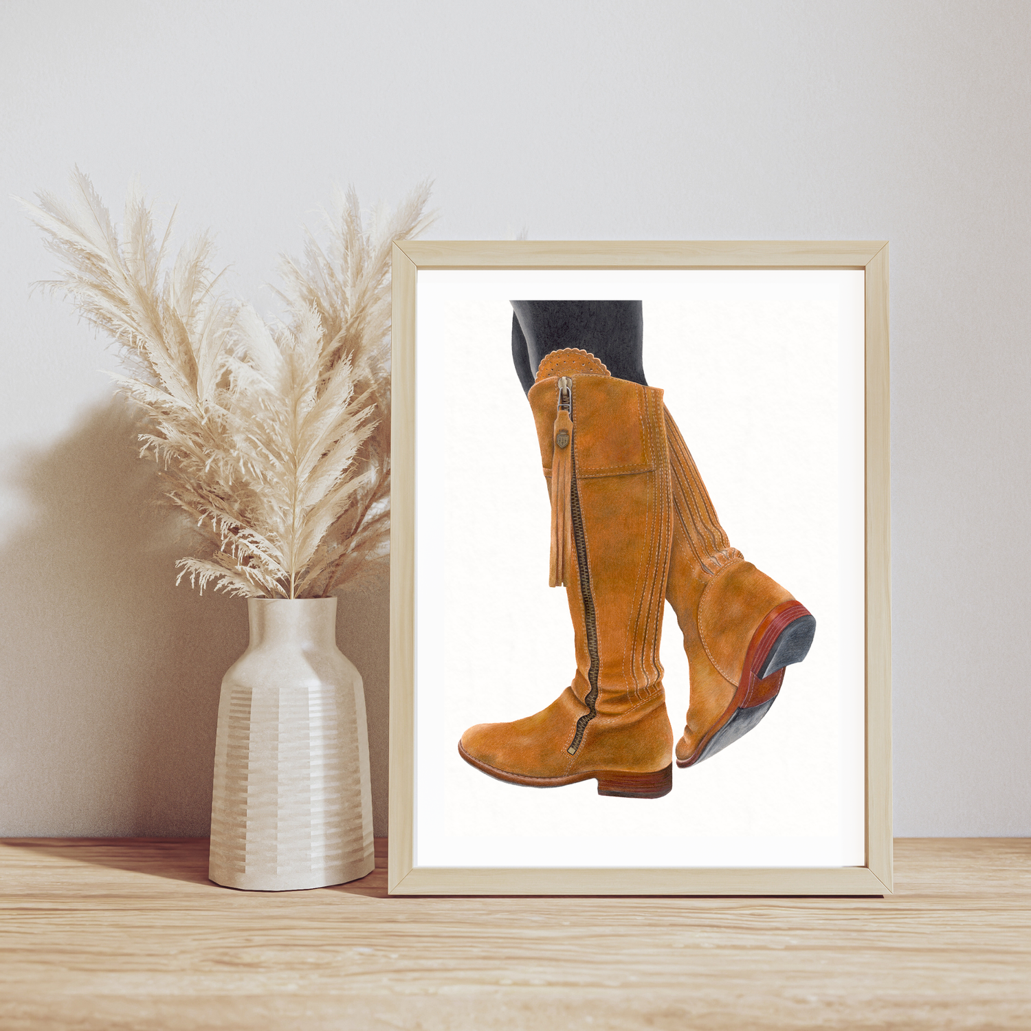 Framed picture of brown boots next to a vase with dried plants on a wooden surface. Country home decor Fairfax and Favor