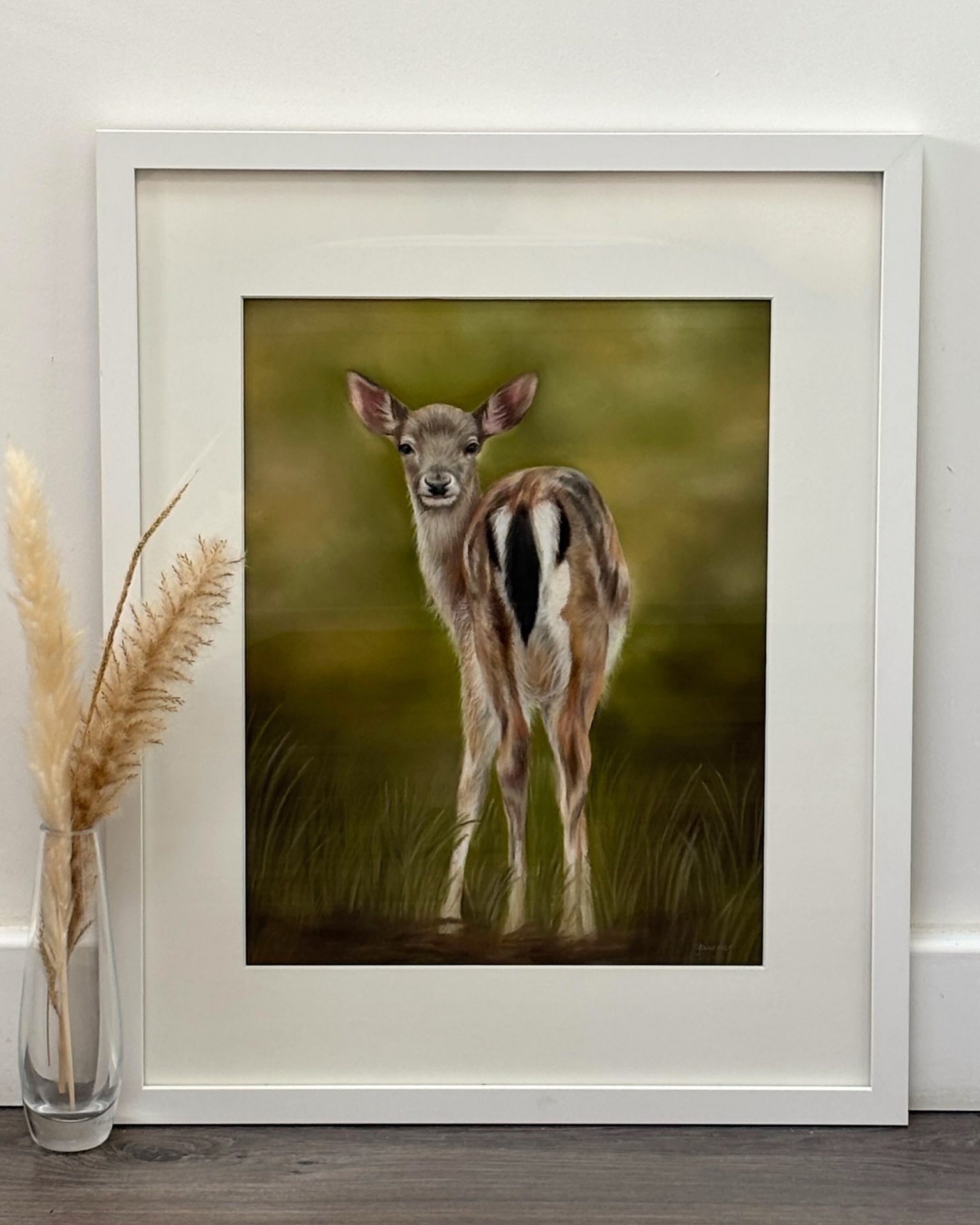 Framed fawn original artwork titled 'Fallow Fawn' displayed on floor with pampas grass, ideal for country home decor and wildlife-themed wall art.