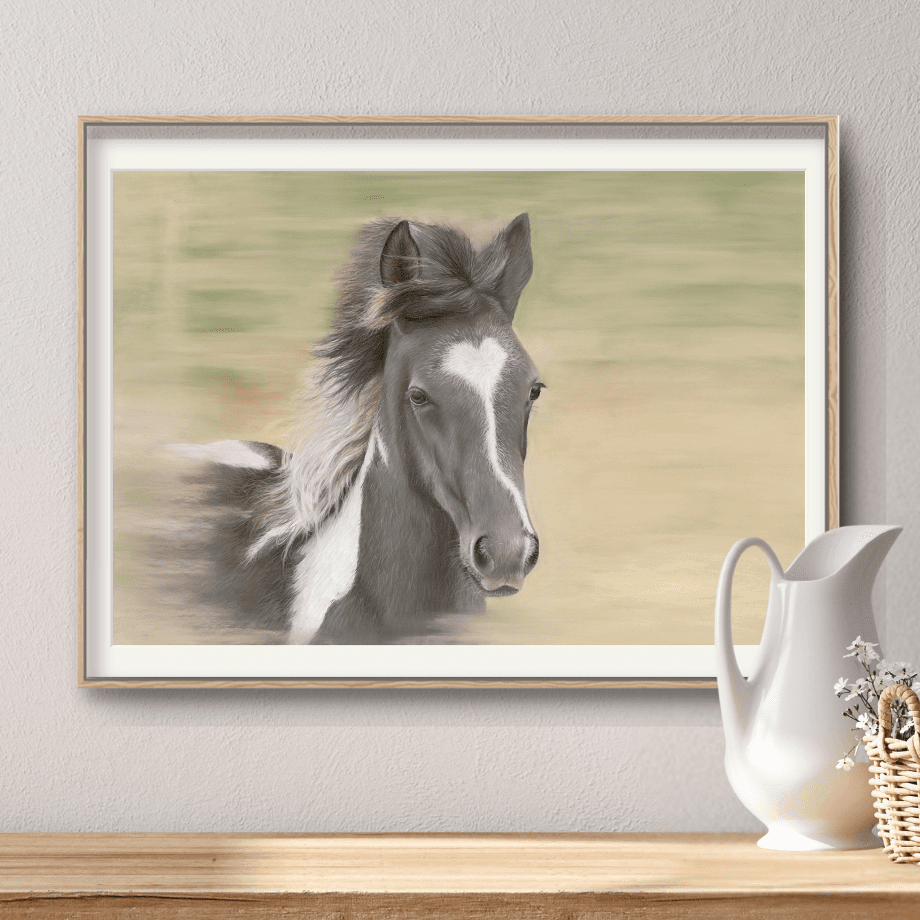 Equestrian Galloping Foal Fine Art Print in a modern frame, styled with a wicker basket and ceramic pitcher for cozy home decor appeal.
