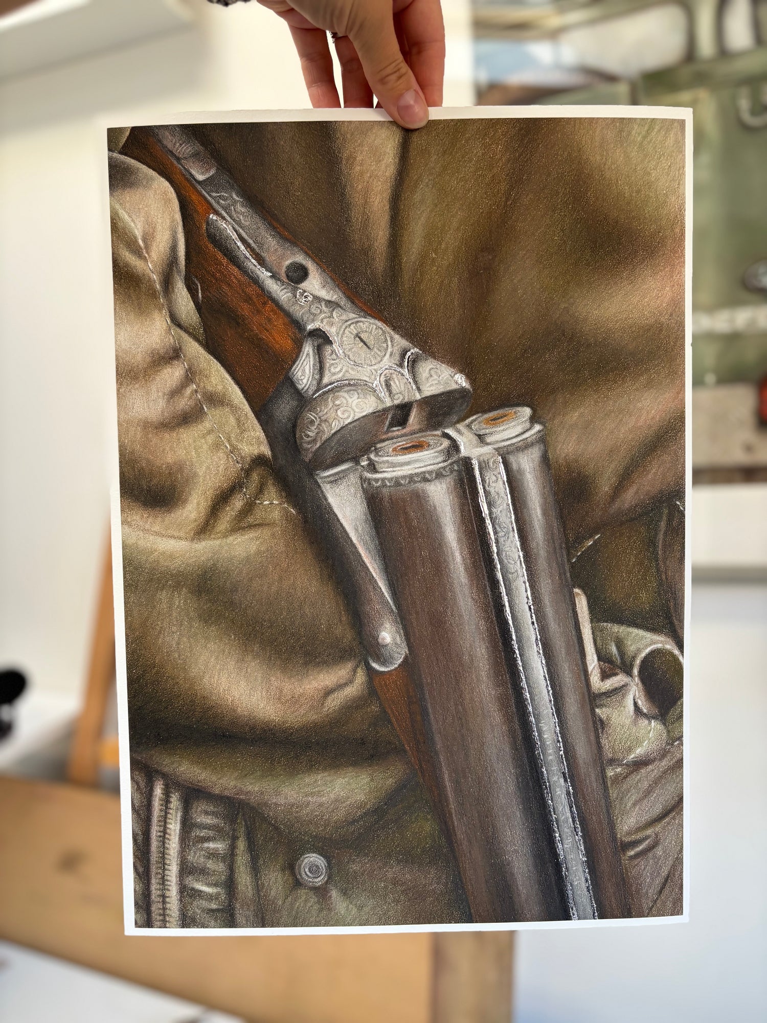 Unframed Country Shoot Fine Art Print held by hand, highlighting realistic detail of double-barrel shotgun and field sport clothing.