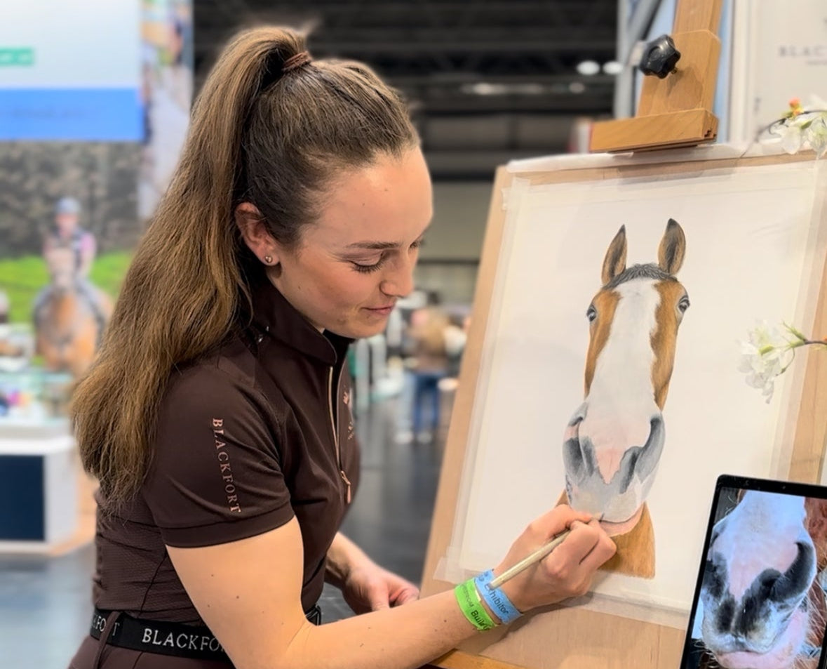 Woman painting a horse on an easel at an event