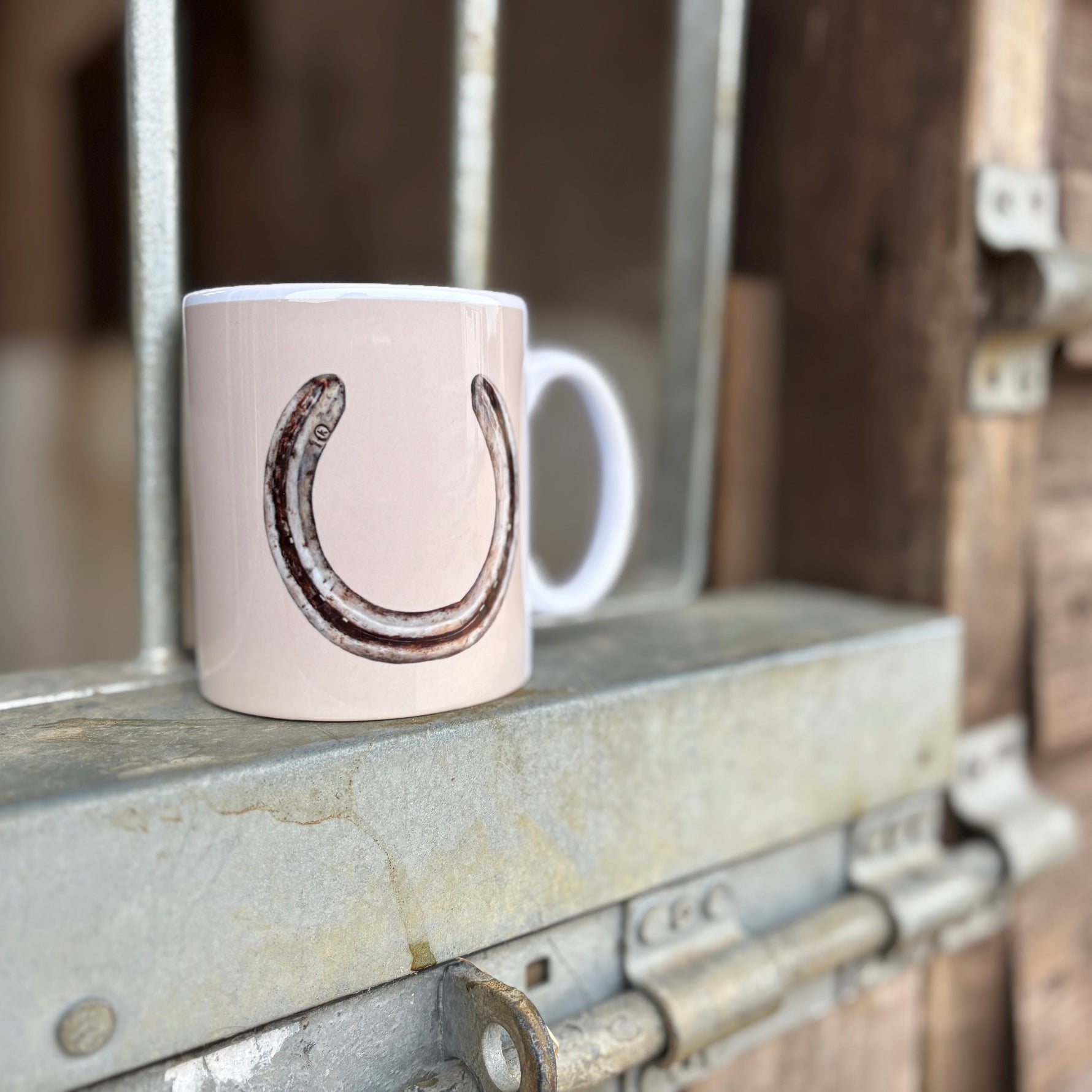 White mug with a horseshoe design on a metal surface
