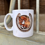 White mug with a horseshoe design on a metal surface