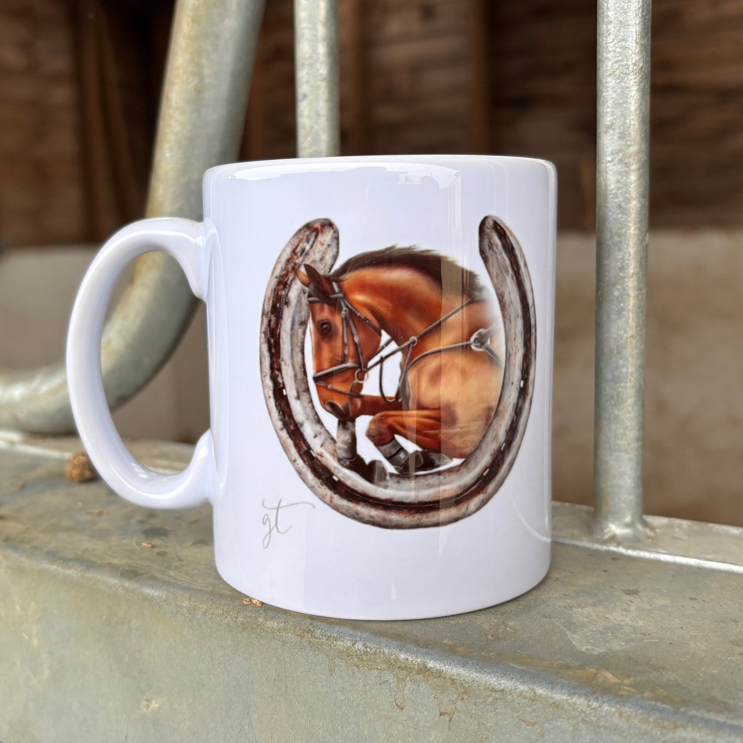 White mug with a horseshoe design on a metal surface