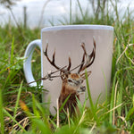 Mug with a deer design placed in grass