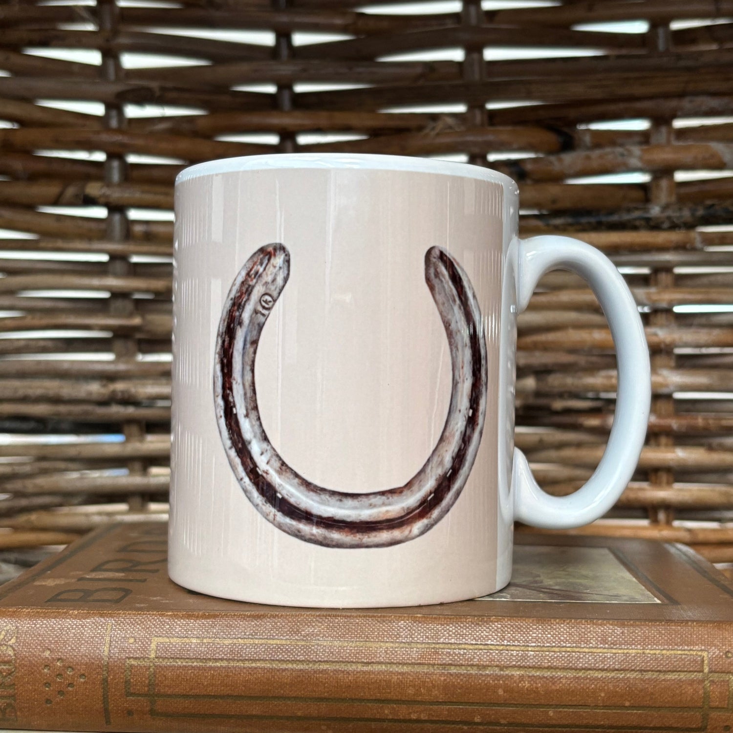 White mug with a horseshoe design on a wooden surface