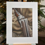 Framed picture of a rifle on a camouflage background with Christmas tree decorations.