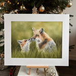 Framed artwork of two foxes on a Christmas tree with ornaments.