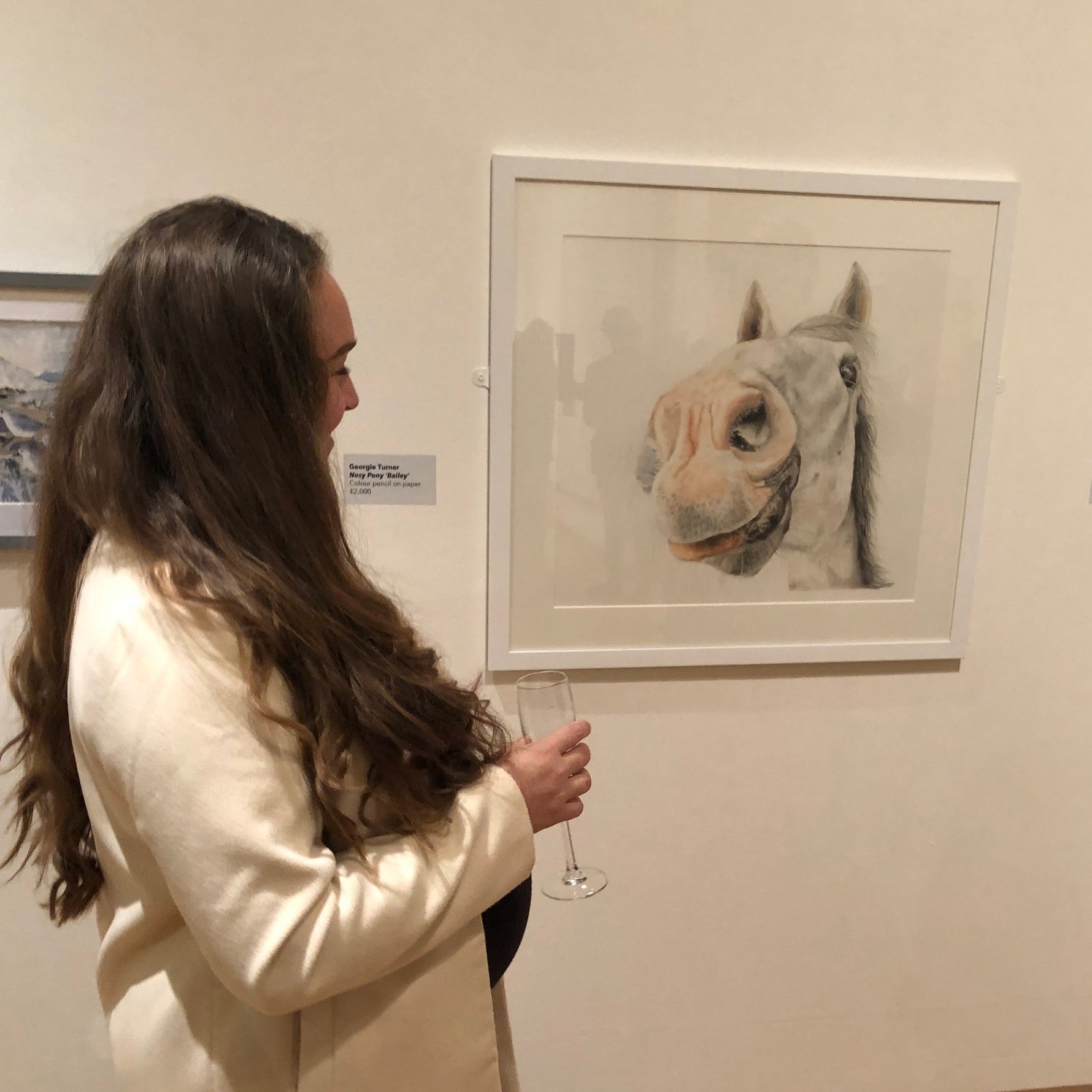 Woman looking at a horse portrait in an art gallery