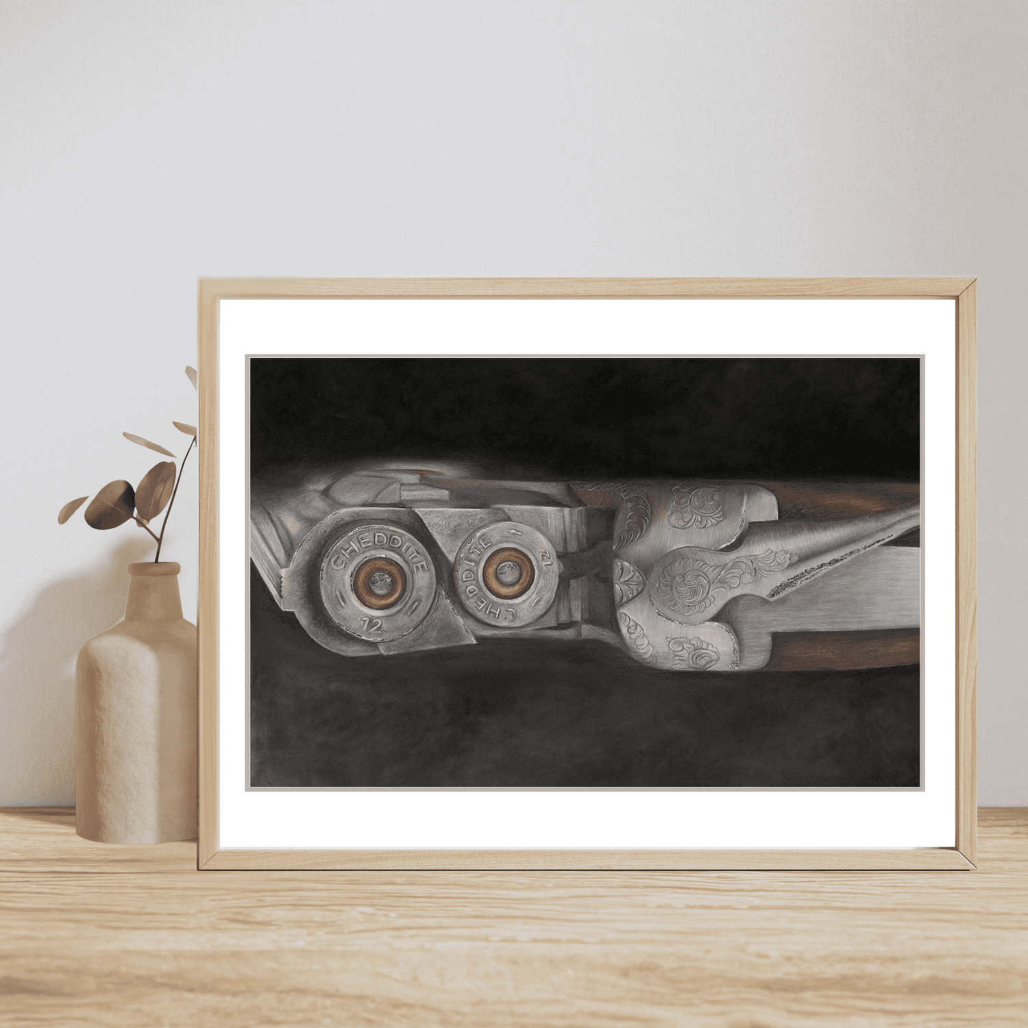 Shooting Fine Art Print showing detailed shotgun engraving and cartridges, framed and styled on a shelf with minimalist ceramic vase and greenery.