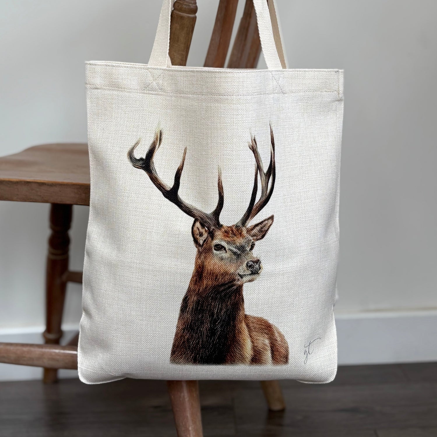Stag tote bag with realistic stag artwork, eco-friendly linen shopping bag hanging on a wooden chair. Ideal tote bag for women and nature lovers.